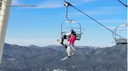 Skier dangles from chairlift