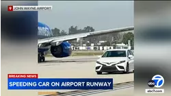 Car speeds past several planes on taxiway at John Wayne Airport in Santa Ana