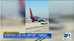 Car speeds past several planes on taxiway at John Wayne Airport in Santa Ana