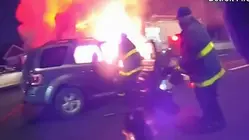 Una mujer queda atrapada en su auto en llamas y los bomberos luchan por salvarla